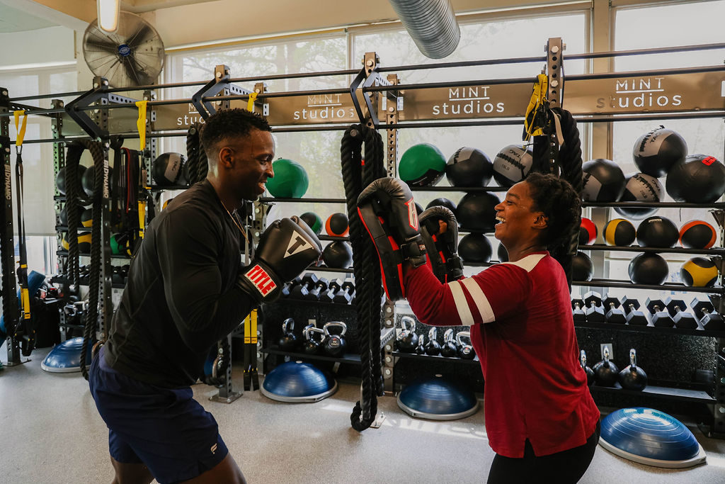 Two MINT members in boxing class laughing