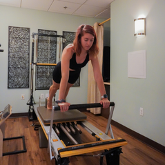 Woman on a Reformer Pilates machine