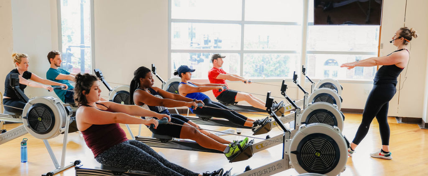 Group of members on a rowing machine during class