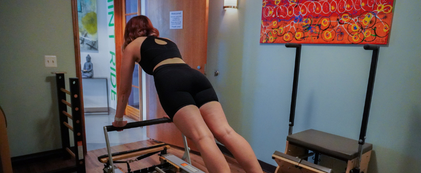 Woman using Reformer Pilates Machine at MINT